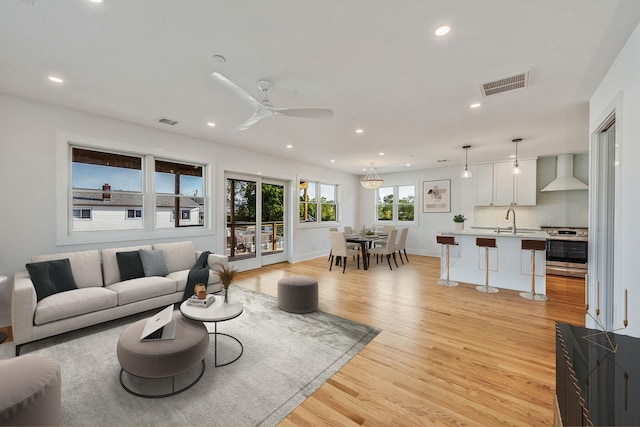 living room featuring ceiling fan, recessed lighting, visible vents, baseboards, and light wood-style floors