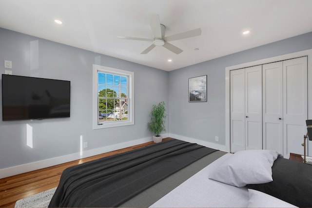 bedroom featuring a closet, recessed lighting, wood finished floors, and baseboards