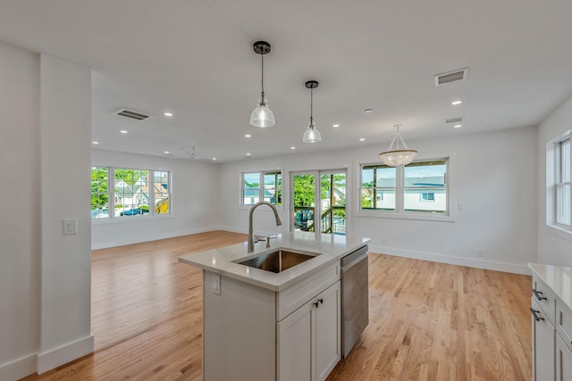 kitchen featuring visible vents, open floor plan, a sink, an island with sink, and dishwasher