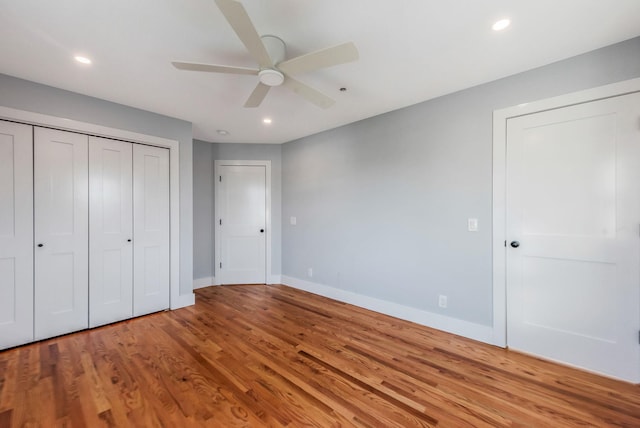 unfurnished bedroom featuring light wood-style flooring, recessed lighting, a ceiling fan, baseboards, and a closet