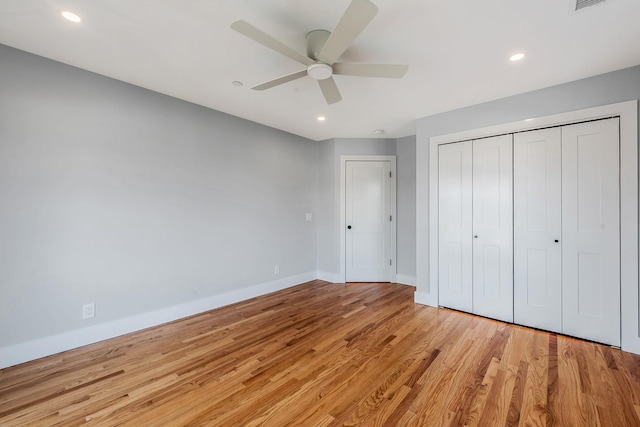 unfurnished bedroom with light wood-style floors, baseboards, a closet, and recessed lighting