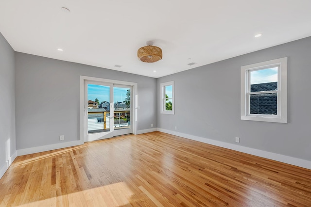 unfurnished room with light wood finished floors, recessed lighting, visible vents, and baseboards