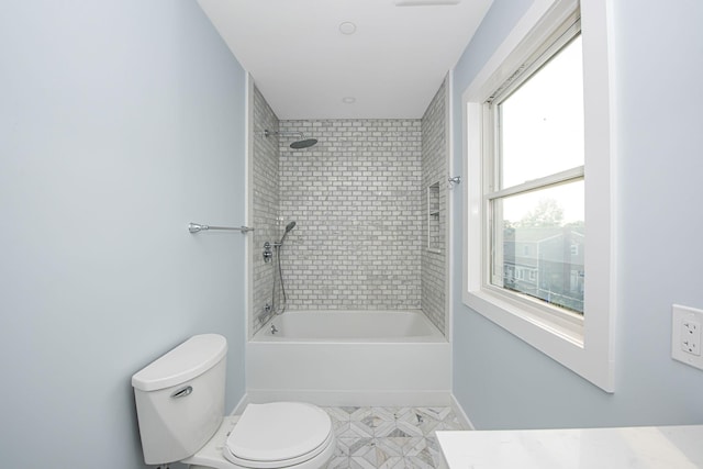 bathroom featuring toilet, baseboards, and bathing tub / shower combination