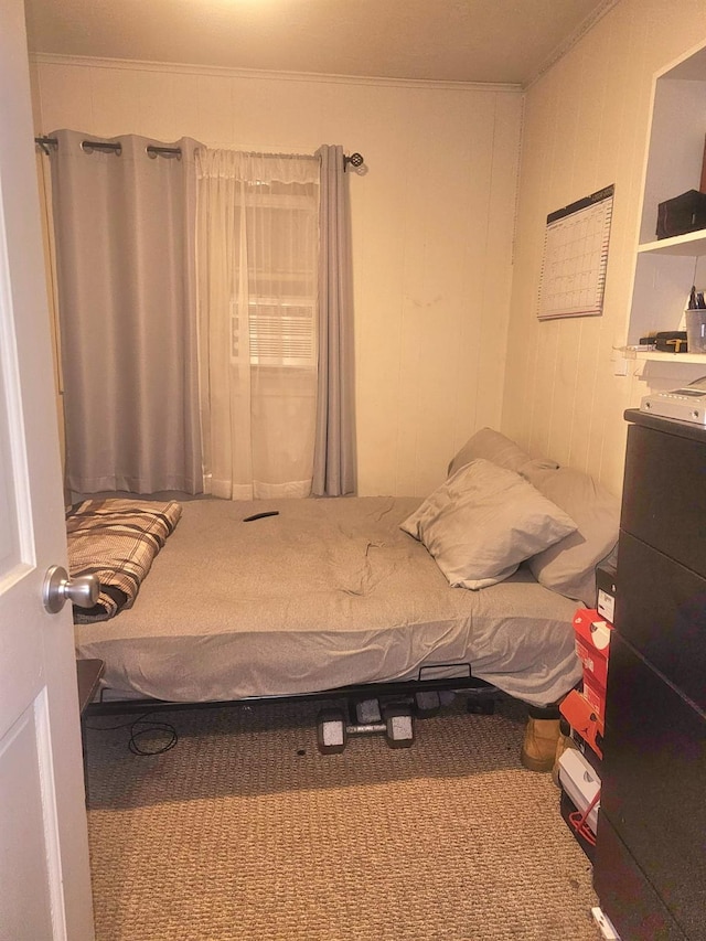 carpeted bedroom with crown molding and wood walls