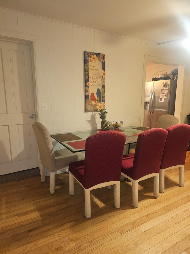 dining area with light wood-style floors and crown molding