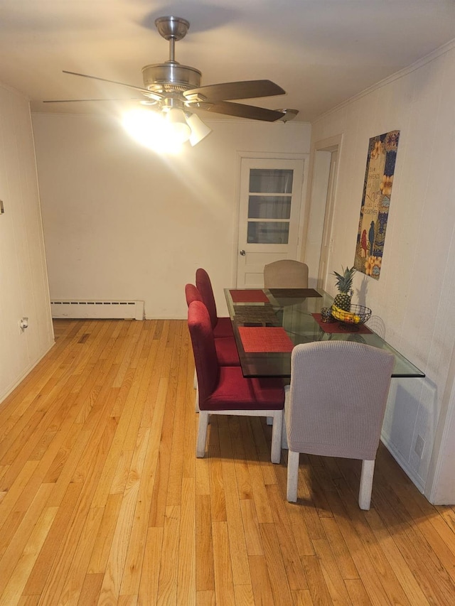 dining room featuring a baseboard heating unit, visible vents, light wood-style floors, and a ceiling fan