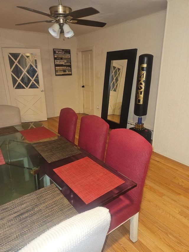 dining area with a baseboard radiator, a ceiling fan, and wood finished floors