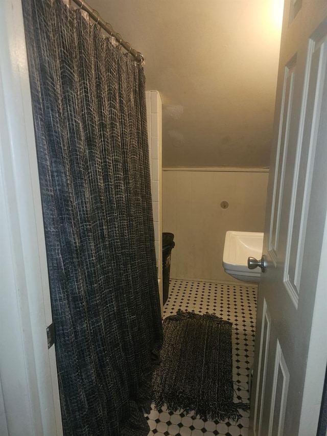 bathroom featuring a shower with shower curtain and a wainscoted wall