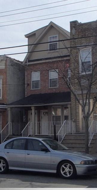 view of property featuring stairway and a porch