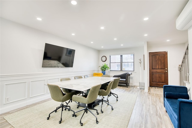 dining space featuring recessed lighting, a wall unit AC, and light wood finished floors