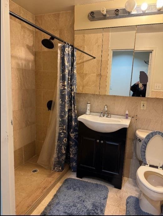 full bathroom featuring vanity, a shower stall, toilet, and decorative backsplash