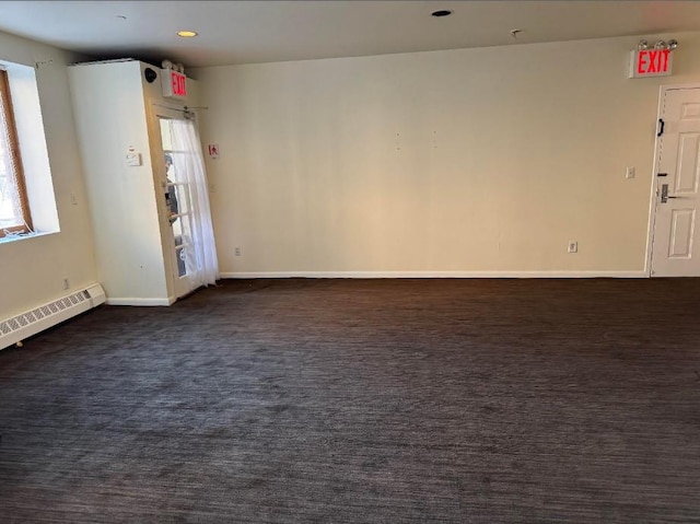 spare room featuring a baseboard heating unit, recessed lighting, dark carpet, and baseboards