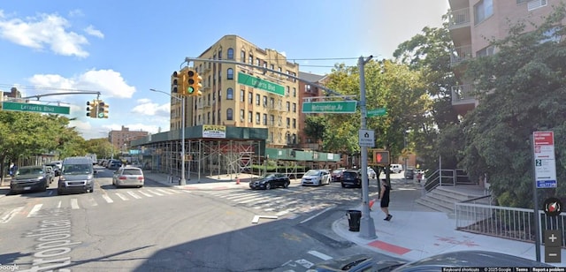 view of road with sidewalks, street lighting, traffic lights, and traffic signs