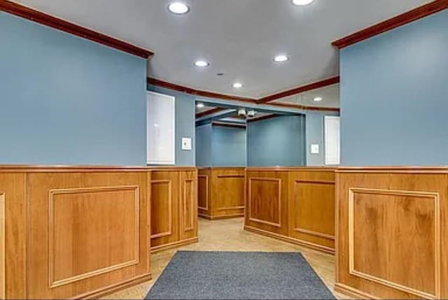 interior space with brown cabinets, recessed lighting, wainscoting, and crown molding