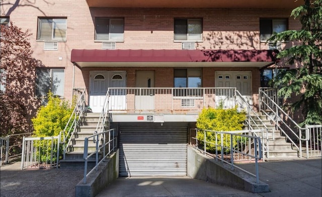 view of front facade with brick siding and stairway