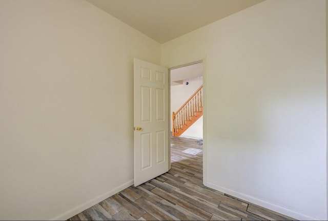 empty room featuring wood finished floors and baseboards