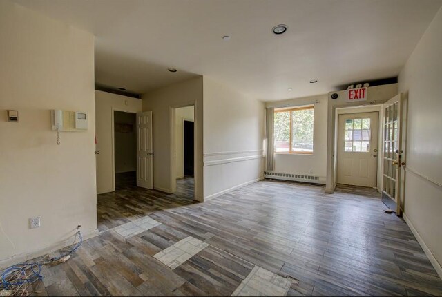 empty room with a baseboard radiator, recessed lighting, and wood finished floors