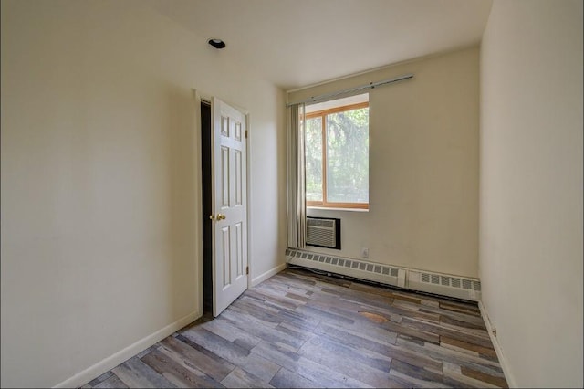 118-82 Metropolitan Ave Unit 1B, Kew Gardens, NY 11415 - empty room featuring baseboard heating, wood finished floors, a wall mounted air conditioner, and baseboards