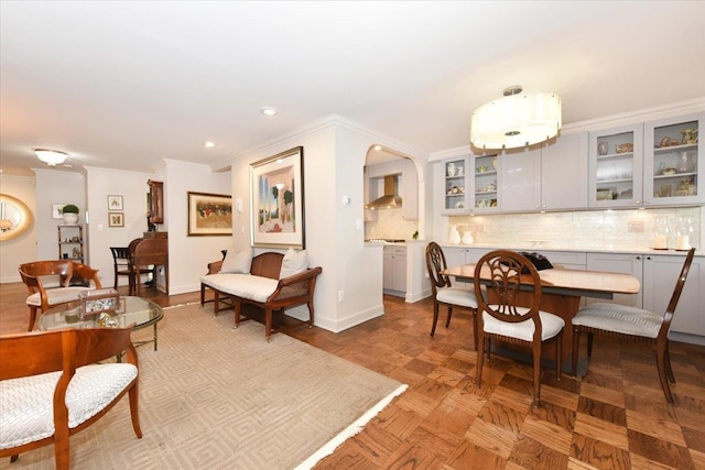 dining space with arched walkways, recessed lighting, baseboards, and ornamental molding