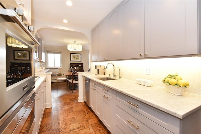 kitchen with light stone countertops, recessed lighting, appliances with stainless steel finishes, and a sink