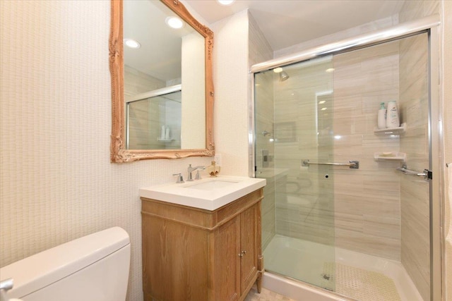 bathroom with vanity, a shower stall, and toilet