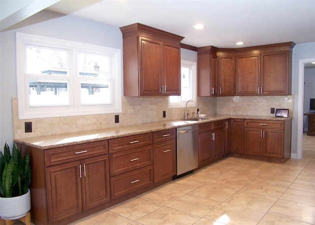 kitchen featuring stainless steel dishwasher, a sink, light stone counters, and tasteful backsplash