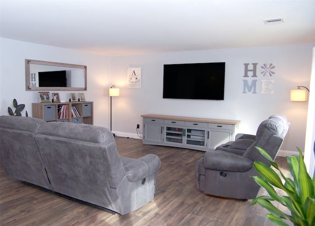 living area with wood finished floors, visible vents, and baseboards