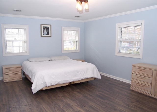 bedroom with dark wood-type flooring, visible vents, crown molding, and baseboards