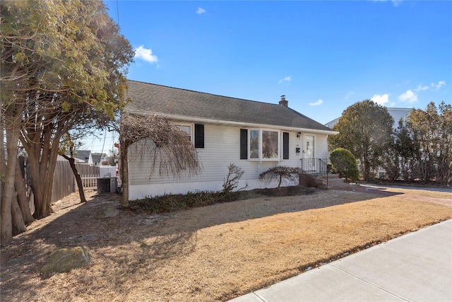 view of front of home with roof with shingles and fence