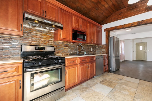 kitchen featuring a sink, stainless steel appliances, light countertops, and under cabinet range hood