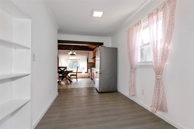 hall featuring baseboards, dark wood finished floors, and crown molding