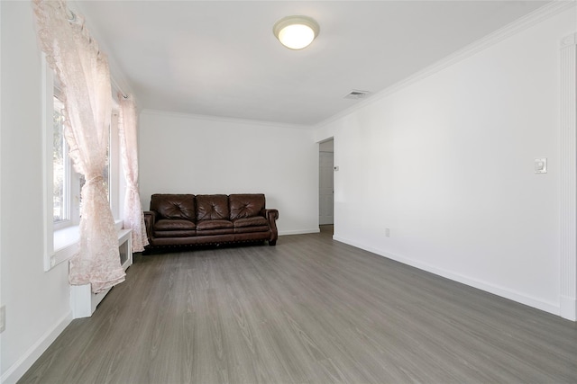 unfurnished room featuring dark wood-style floors, visible vents, crown molding, and baseboards