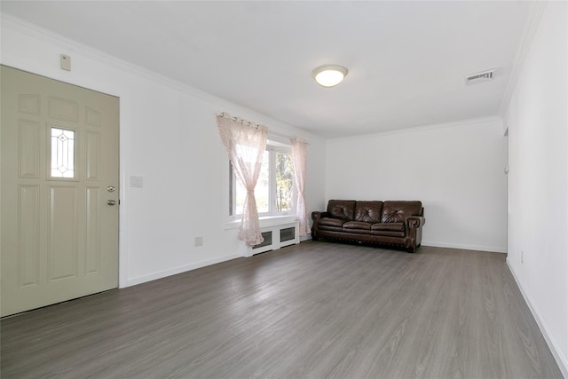 unfurnished room with visible vents, crown molding, baseboards, and wood finished floors