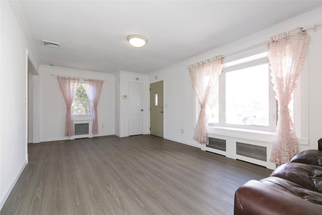 living room with a fireplace, visible vents, baseboards, ornamental molding, and dark wood finished floors