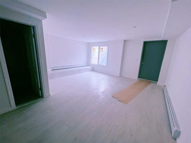 empty room featuring light wood-style floors and baseboard heating