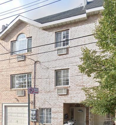 view of front of house featuring a wall mounted air conditioner and brick siding