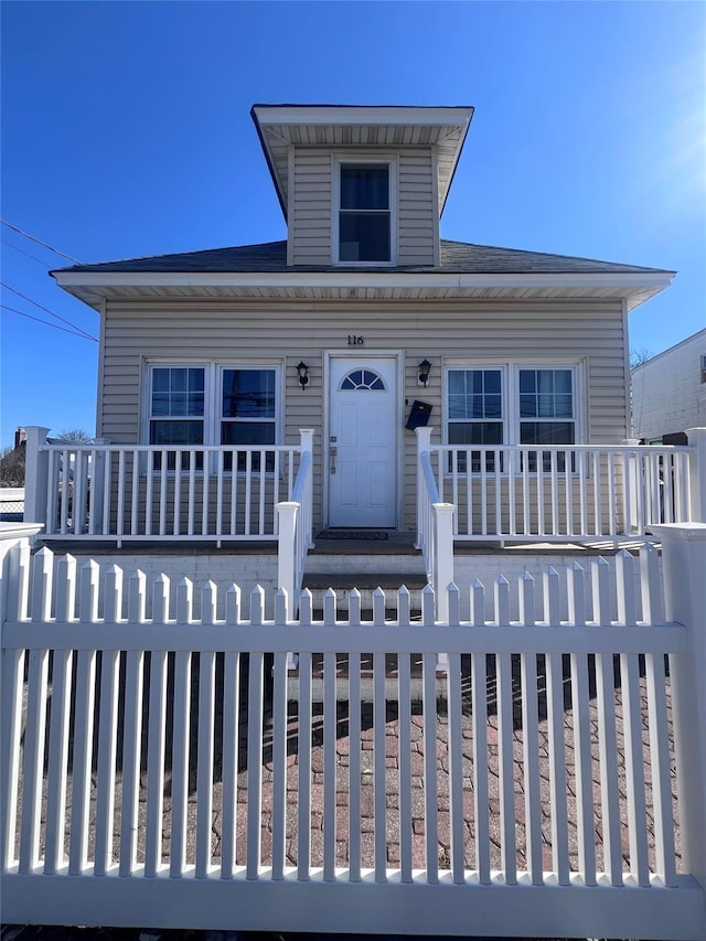 view of front of property featuring a fenced front yard and a porch