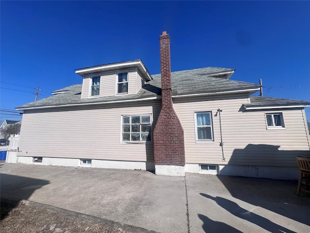 rear view of property featuring a patio area and a chimney