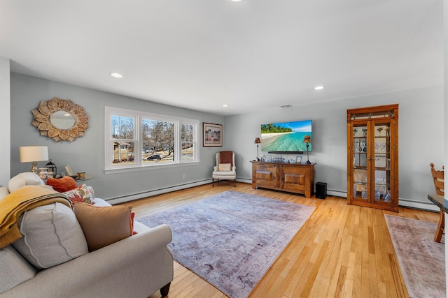 living area featuring a baseboard radiator, hardwood / wood-style flooring, and recessed lighting