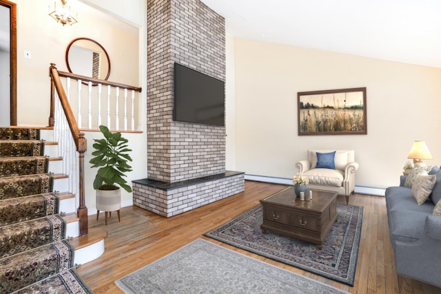 living room featuring lofted ceiling, a baseboard radiator, a baseboard heating unit, wood finished floors, and stairway