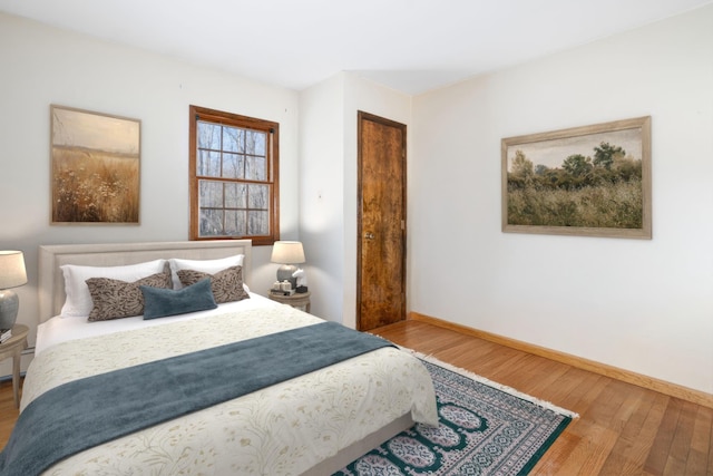 bedroom with baseboards and wood finished floors