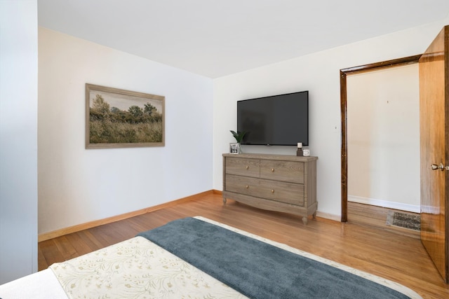 bedroom with wood finished floors and baseboards