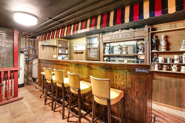 bar with a dry bar and tile patterned floors