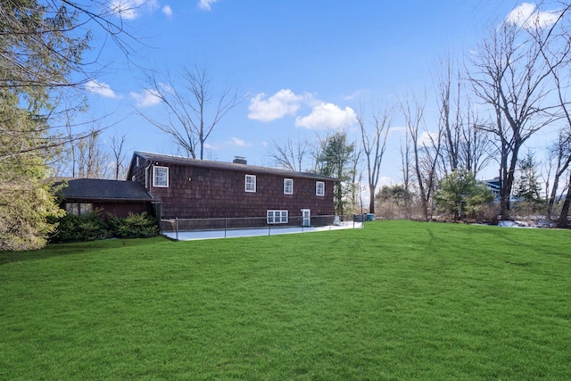 rear view of property featuring a lawn and a chimney