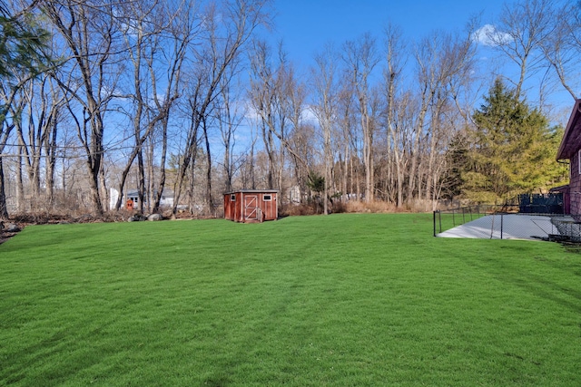 view of yard with a storage shed, an outbuilding, and fence