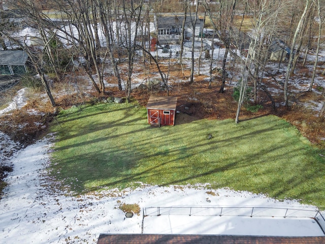 yard covered in snow featuring a storage unit and an outdoor structure