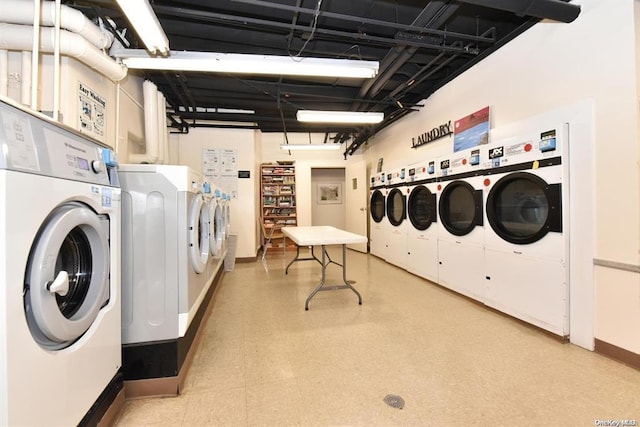 community laundry room featuring light floors and washing machine and clothes dryer