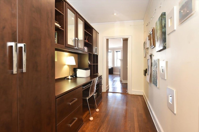 hall featuring baseboards, ornamental molding, and dark wood-style flooring