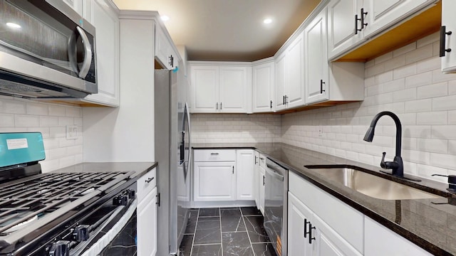 kitchen featuring appliances with stainless steel finishes, marble finish floor, white cabinets, and a sink