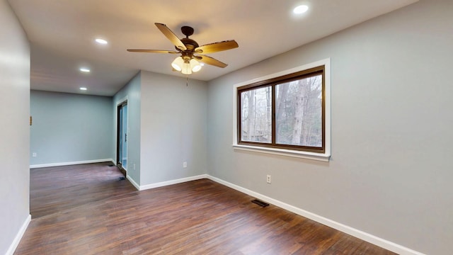 unfurnished room with dark wood-style floors, visible vents, baseboards, and recessed lighting